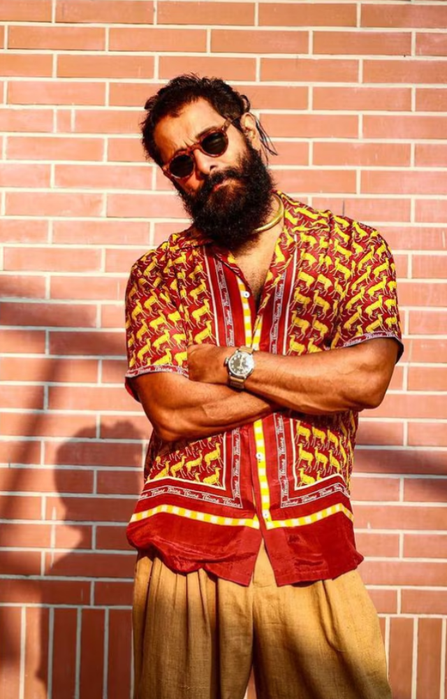 Vikram showcased fashion sense with vibrant, printed oversized shirts paired with striking trousers in colors like orange and yellow during the PS2 press event.