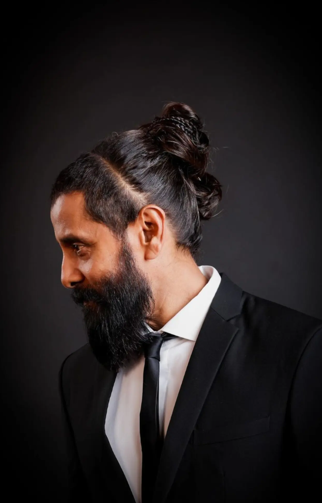 His distinctive man bun continues to turn heads, adding an edgy yet polished vibe to his overall look.