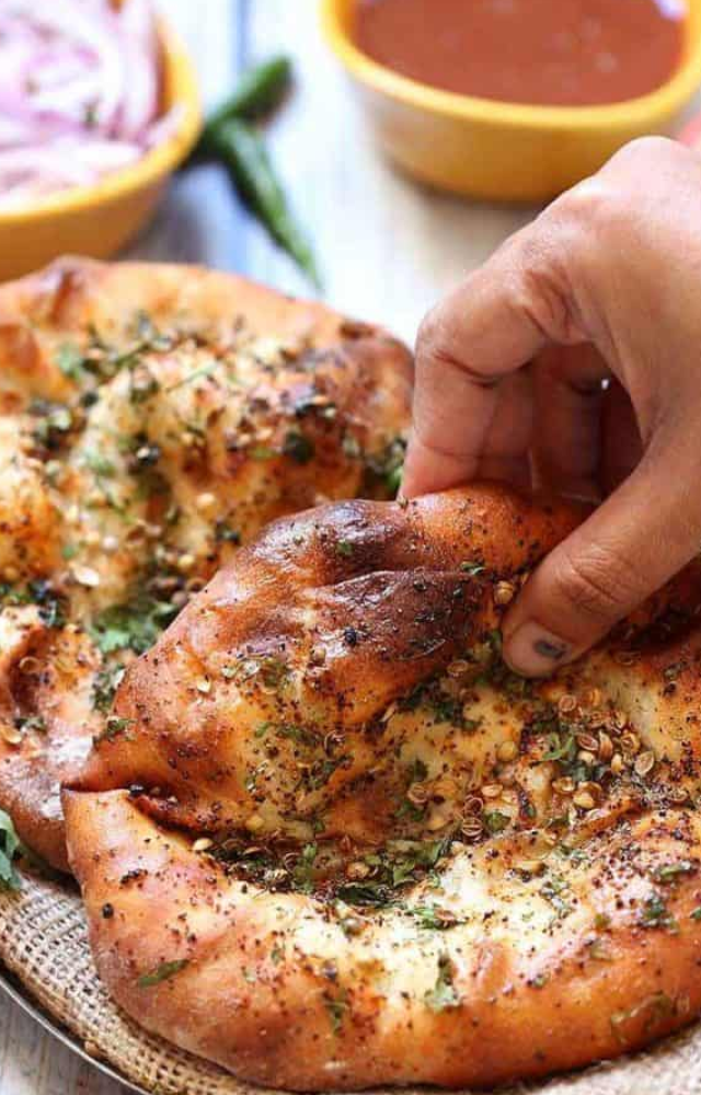 A delicious flatbread stuffed with potatoes, onions, and spices, often garnished with coriander seeds and cilantro.