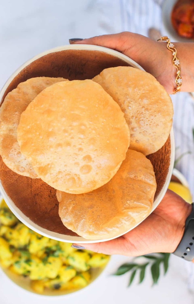 Deep-fried bread made from wheat flour, served with a side of potato curry or other vegetable dishes.