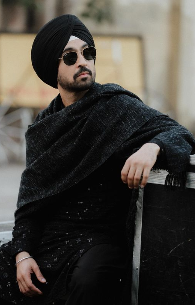 Diljit Dosanjh conjures up a spell of charm and charisma in an alluring black costume, conjuring up an enthralling atmosphere of ageless appeal.