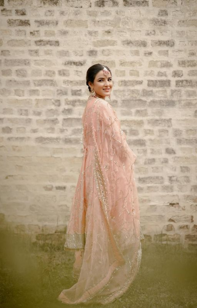 Jasmin decked up from head to toe in jewellery which includes a choker set, maang tika, as well as a red choora with kaleeras