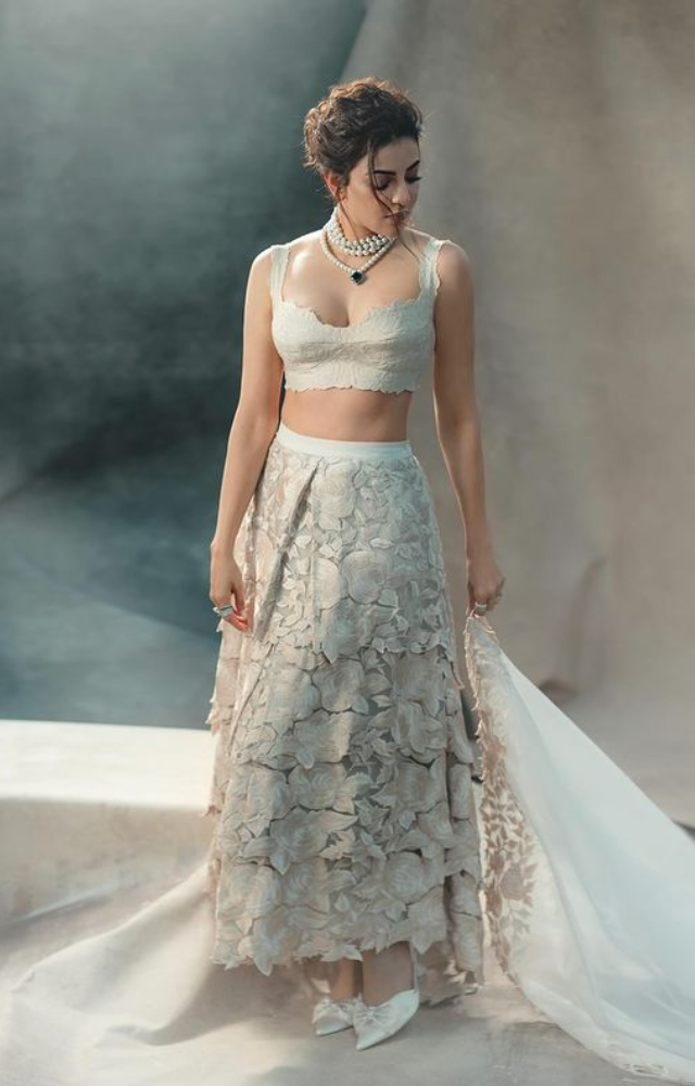 Recently, she captivated in a white lehenga ensemble, adorned with pearls, styled with a messy bun, and complemented by white heels.
