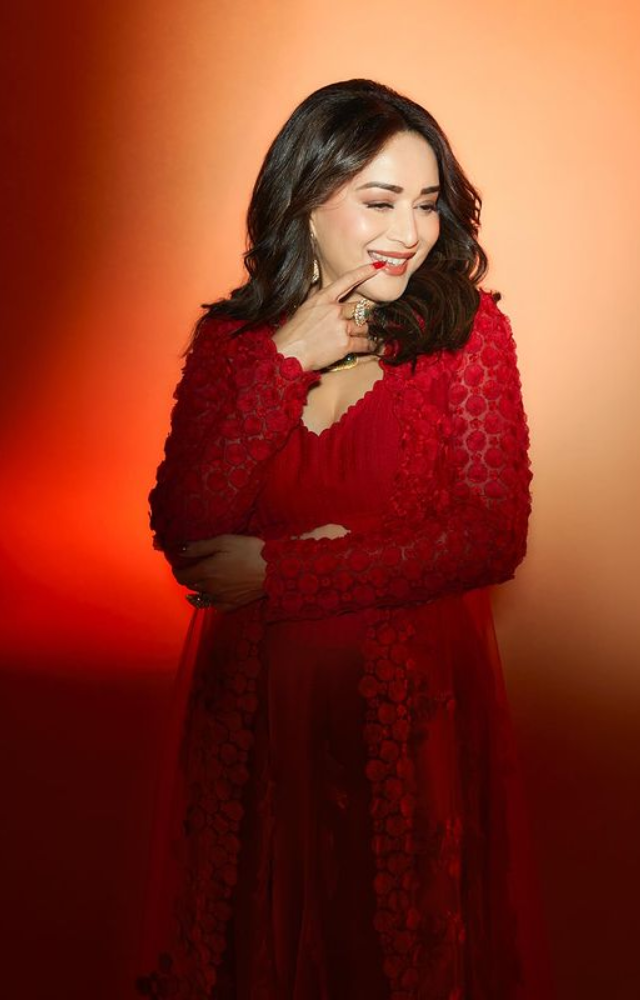 Madhuri Dixit reignites the screen in a sizzling red outfit, exuding the same enchanting allure that made her the eternal `Dhak Dhak` girl.