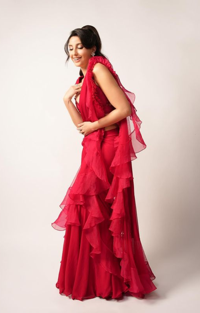 Nora Fatehi sets the stage ablaze in a cherry red saree, weaving a spell of sophistication and allure.