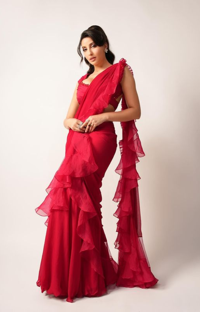 Nora Fatehi slays in a cherry red saree, a stunning blend of tradition and modern allure.