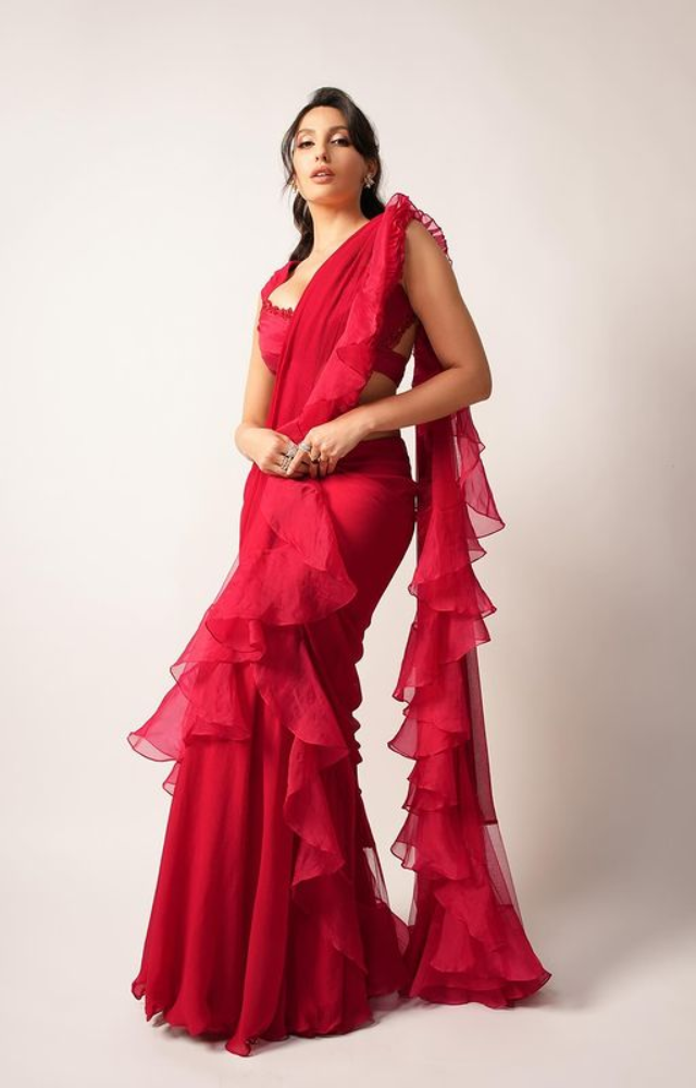 Nora Fatehi dons a cherry red saree, transforming into a goddess of glamour.