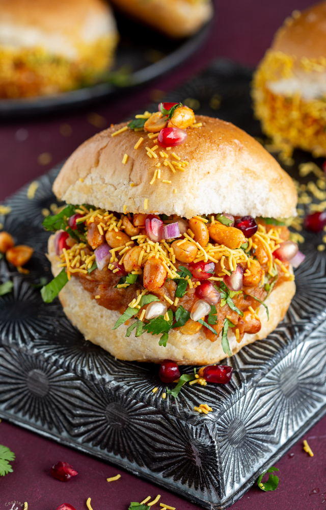 Dabeli is a well-known street dish that consists of a spiced potato filling between two pieces of pav bread, accompanied by tamarind chutney, garlic chutney