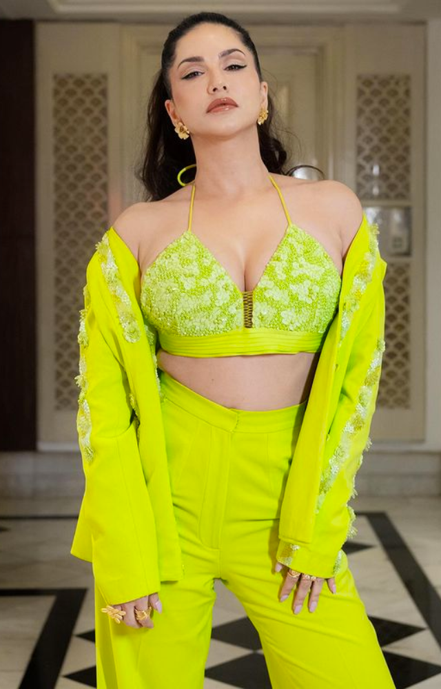 Sunny Leone sizzles in a hot green floral ensemble, igniting the screen with her captivating allure, combining sensuality and floral elegance seamlessly.