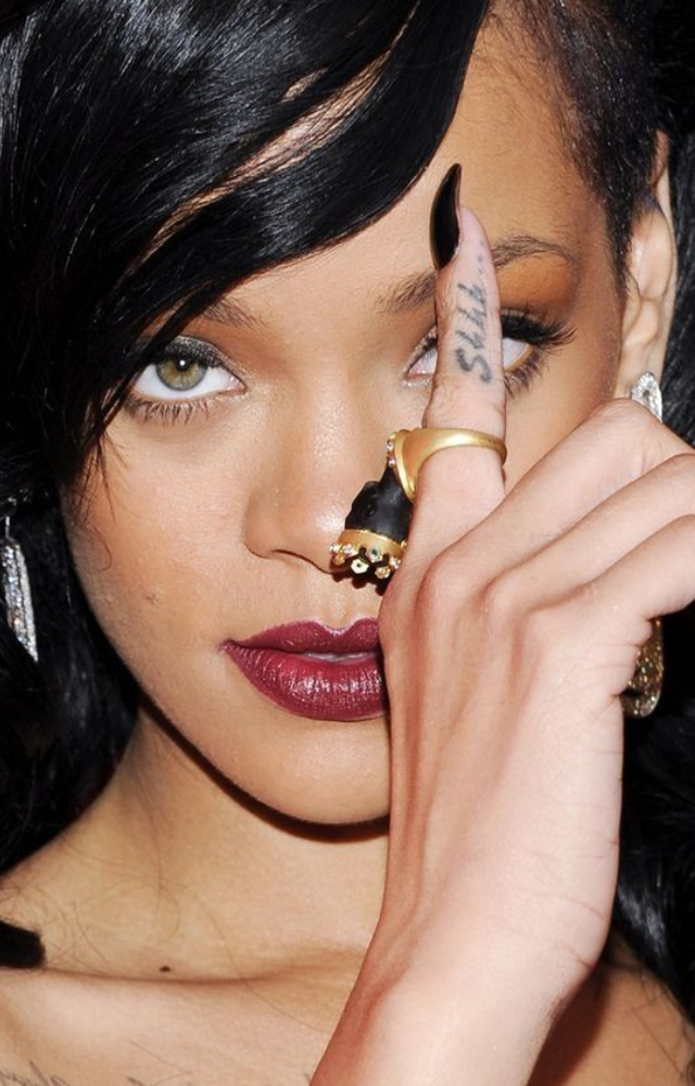 Rihanna’s tiny “SHH…” inked On her finger symbolizes her mantra to find calm in chaos—reminding her to listen more than she speaks.
