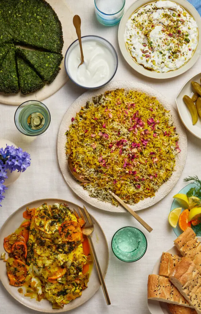 Dishes like Sabzi Polo (herb rice), Kuku Sabzi (herb frittata), and Ash Reshteh (noodle soup) are staples of the celebration, implying renewal and good fortune.