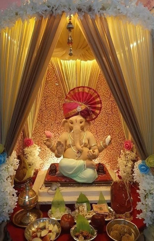 Illuminate your space with fairy lights and traditional oil lamps (diyas) to create a warm, festive glow around your Ganpati idol.
