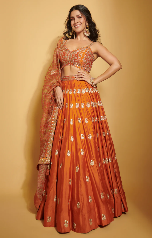 Bringing vibrance to ethnic fashion, Nimrat shines in an orange lehenga, exuding charm and festive energy.