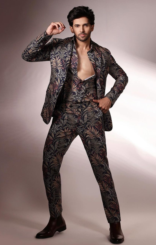 Shehzada Dhami stands out in Bigg Boss 18 with his bold and edgy looks, showcasing vibrant prints and striking accessories.